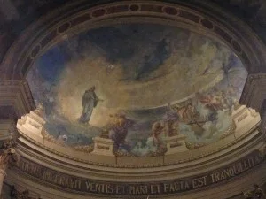 Affresco della volta absidale con figure e scritta latina lungo il cornicione