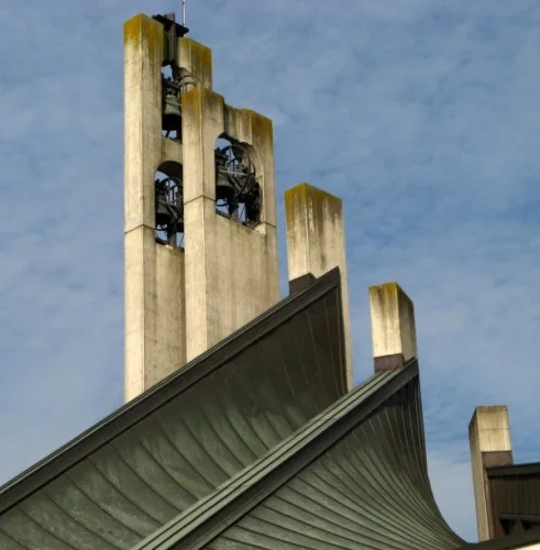Il campanile a vela del nuovo santuario, in cemento chiaro, con le campane